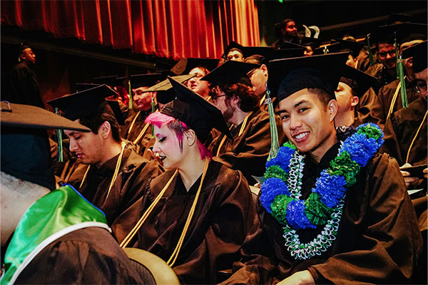 Photo of 2023 USV graduates in their caps and gowns at their commencement ceremony.